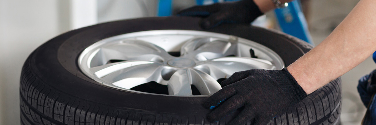 Mechanic picking up a tyre - Tyres Whitstable